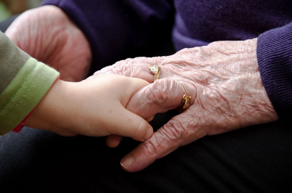 A child's hand holding an older person's hand