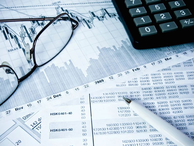 Financial charts, glasses and a calculator